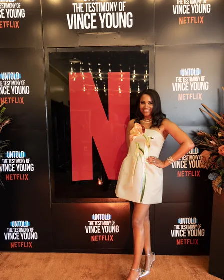 Guest in a cream dress in front of the backdrop