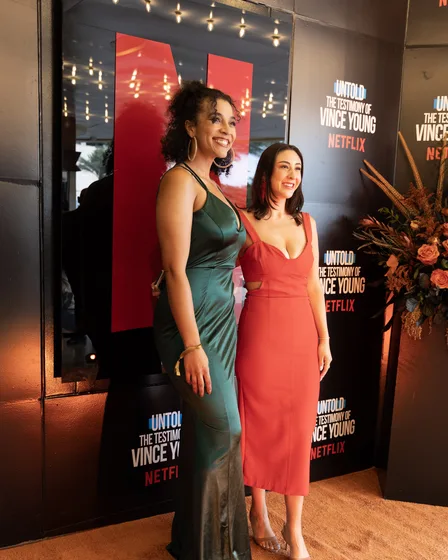 Two guests in evening gowns on the orange carpet