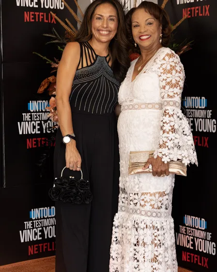 Two guests in evening wear on the orange carpet