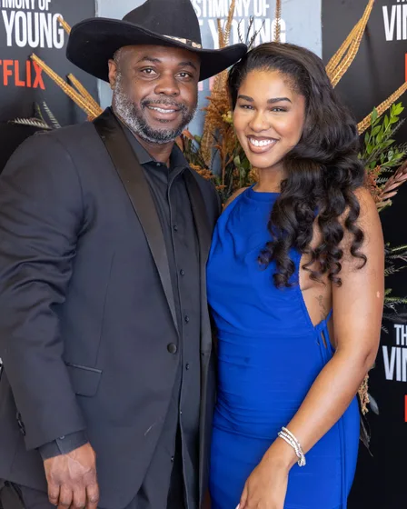 Two guests posing together in front of the backdrop